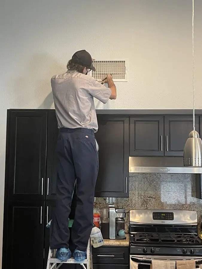 Technician inspecting an air vent during HVAC service in Port Lavaca